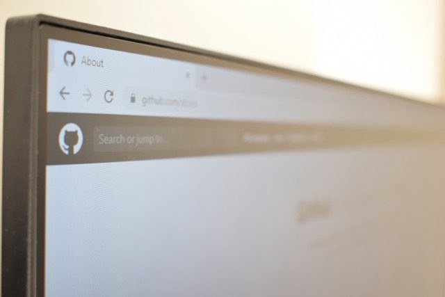 A close-up of a monitor displaying a GitHub repository page in a browser.